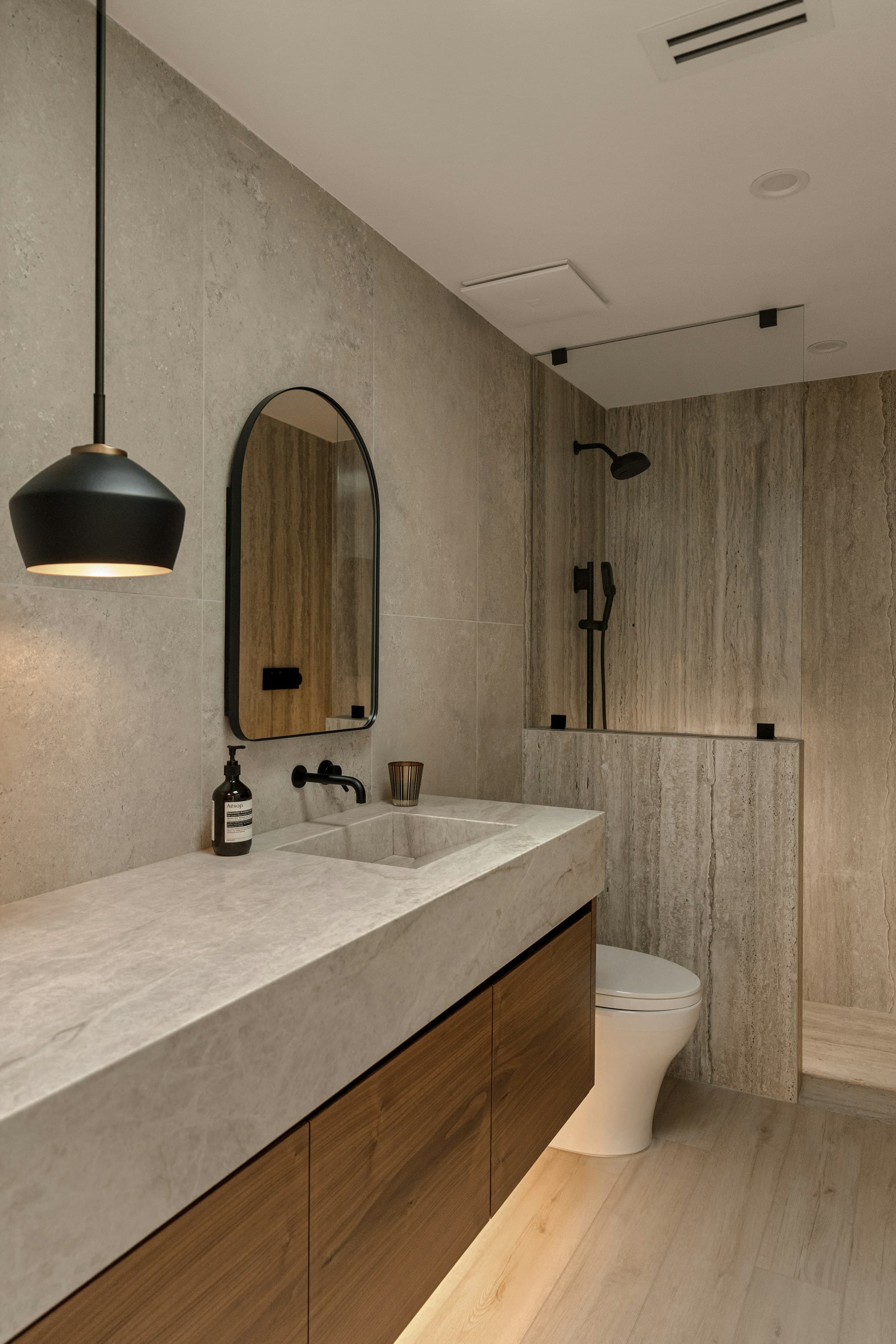 Salle de bains rénovée, carrelage soigné et sanitaires contemporains.